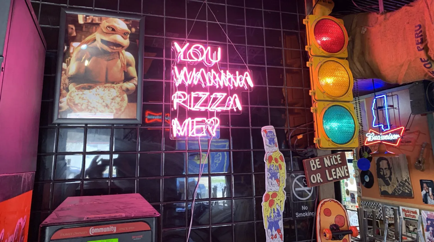 Neon signs and eclectic decorations inside a Lost Pizza Co. restaurant